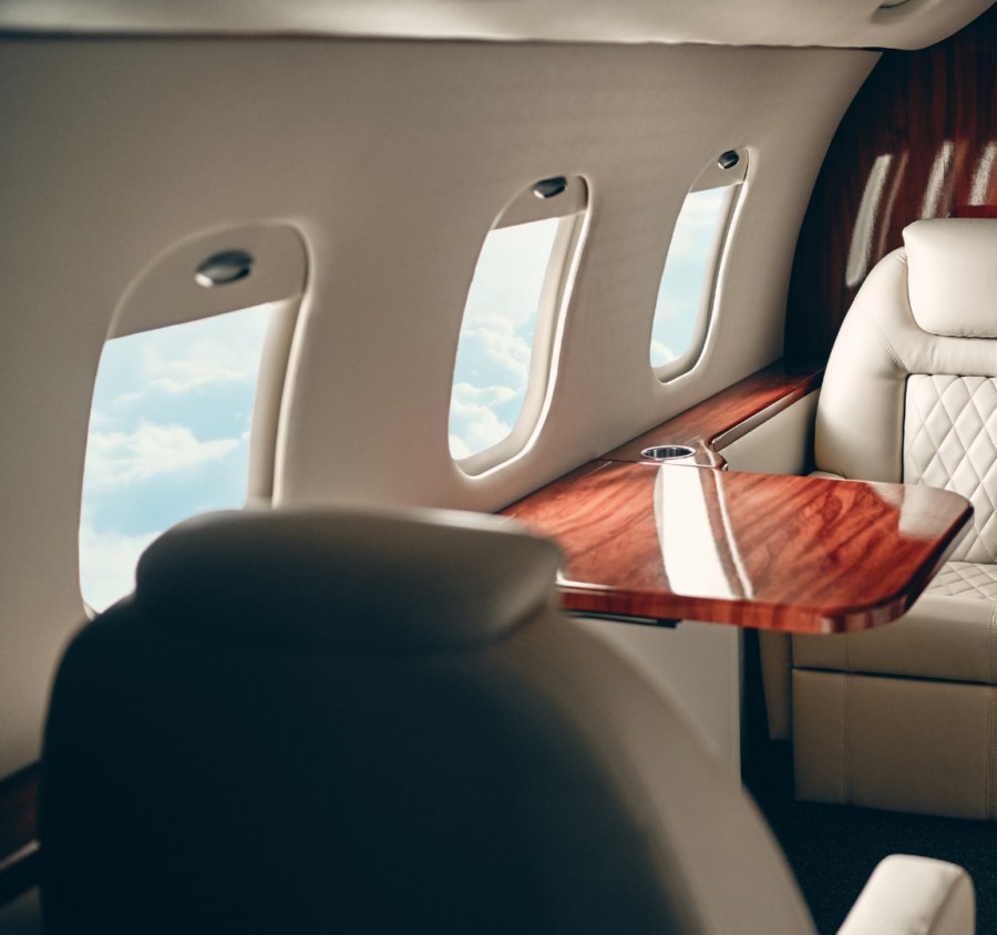 Cabine de jet privé vue sur les hublots avec fauteuils en cuir crème