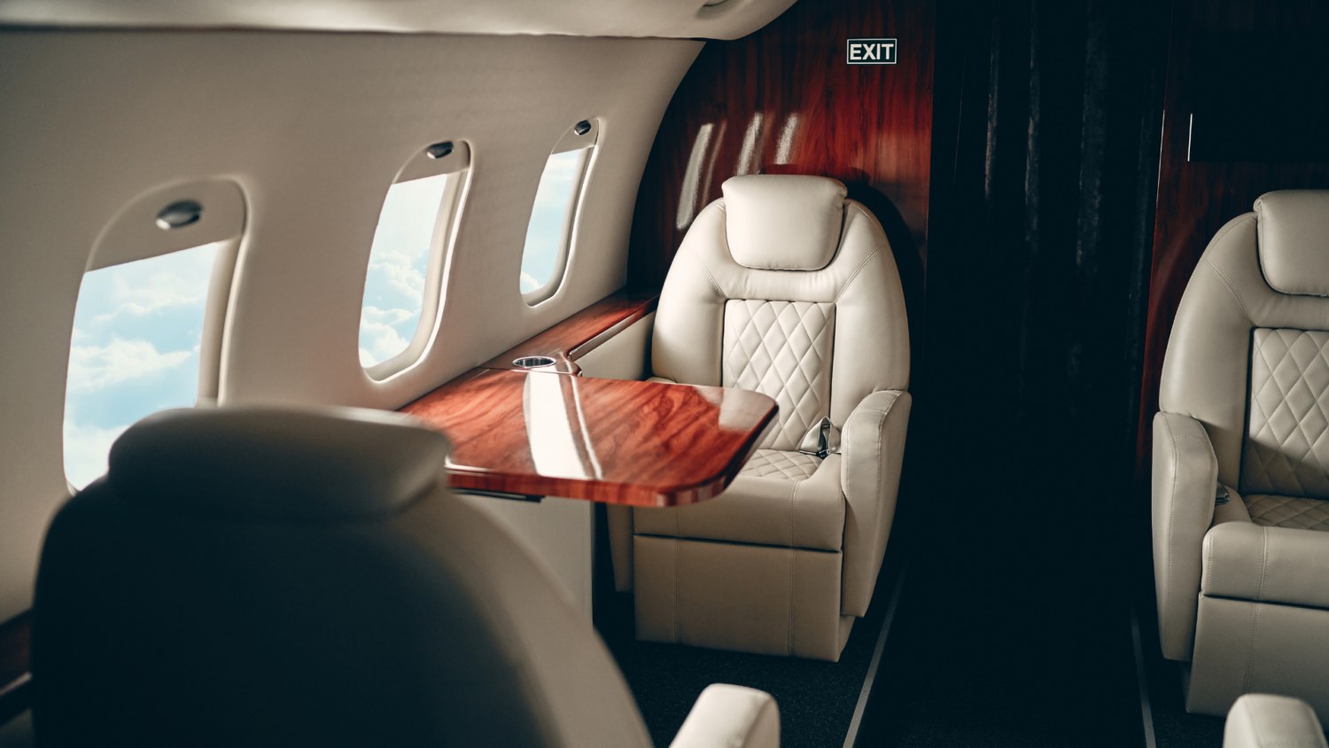 Fauteuil en cuir crème et tablette en bois précieux dans une cabine de jet privé